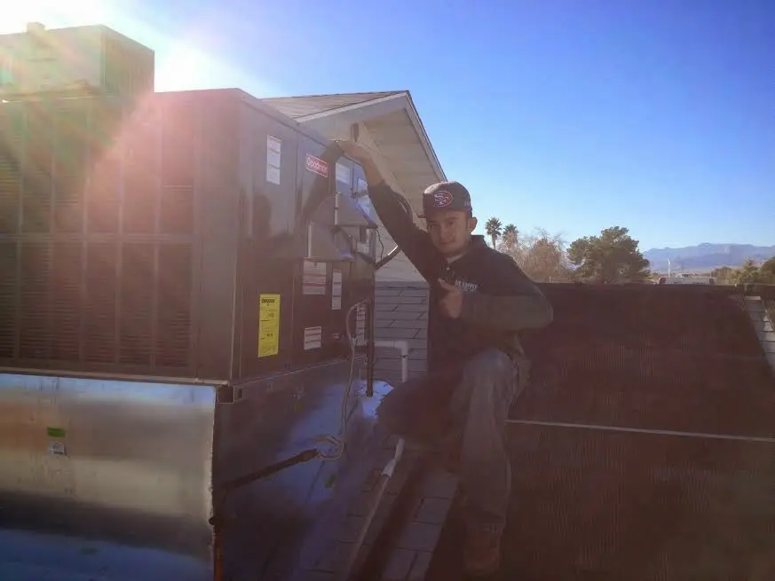 HVAC technician performing Air Duct Repair on a rooftop unit in Austell